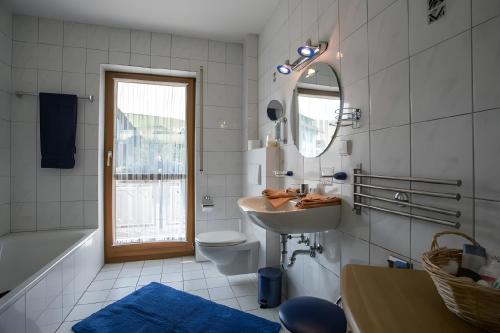a bathroom with a sink and a toilet and a mirror at Ferienwohnung Echle in Oberharmersbach