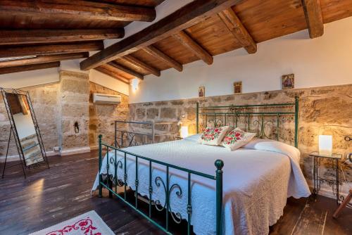 ein Schlafzimmer mit einem Bett in einem Zimmer mit Holzdecke in der Unterkunft Alghero Old Town Charm - Sardinia in Alghero