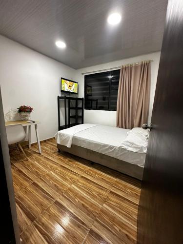 a bedroom with a bed and a table and a window at 306ApartaesudioRomance in Arauca