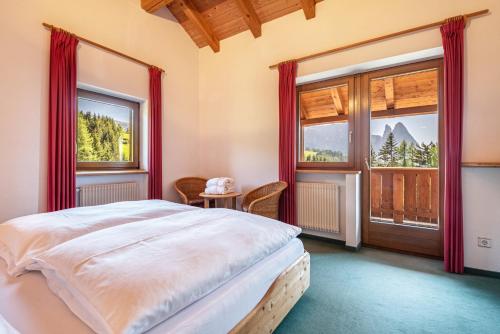 a bedroom with a bed and a large window at Sabina Dolomites Latsche in Alpe di Siusi