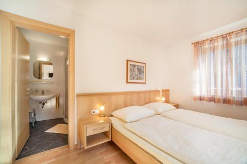 a bedroom with a large bed and a bathroom at Parigger Apt Zirbe in Racines