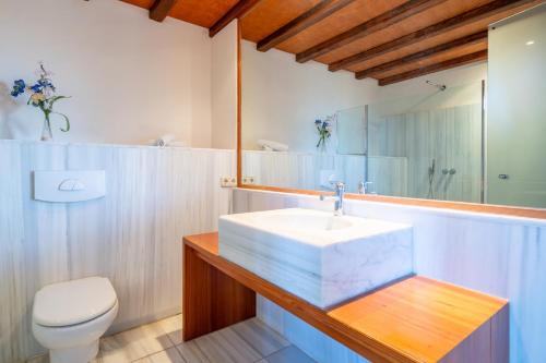a bathroom with a sink and a toilet and a mirror at Can Rito in Islas Baleares