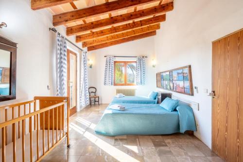 a bedroom with two beds and a wooden staircase at Can Rito in Islas Baleares