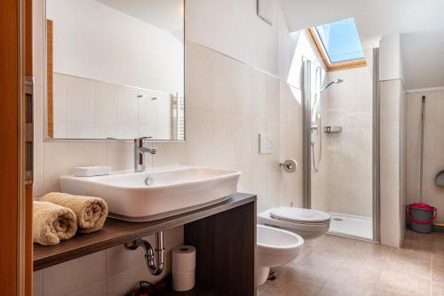 a white bathroom with a sink and a toilet at Mongaduierhof Apt Tschafon in Umes
