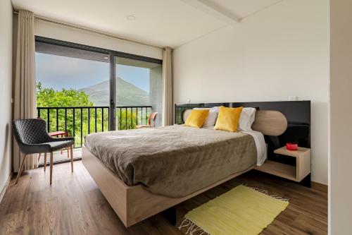 a bedroom with a large bed and a balcony at Felicidade in Mondim de Basto