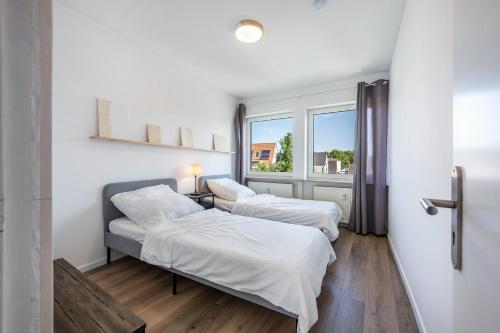 two beds in a room with a window at Ferienwohnung mit Dachterrasse in Heide