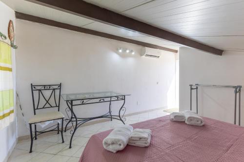 a bedroom with a bed and a table and chairs at Villa Forino Ragusa in Santa Maria del Focallo