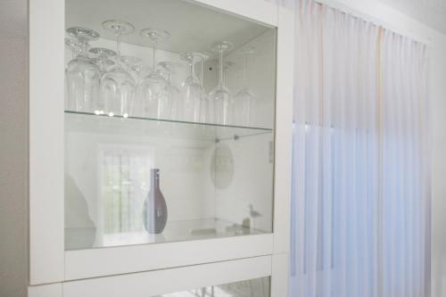 a cabinet filled with glass vases and a bottle at Strandnaher Bungalow in Dierhagen