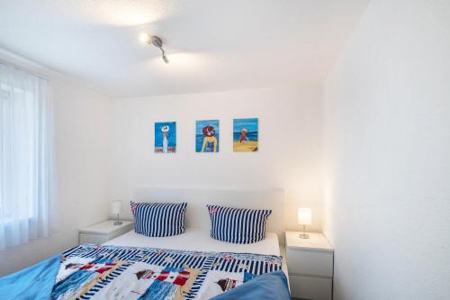 a bedroom with a bed with blue and white pillows at Strandnaher Bungalow in Dierhagen