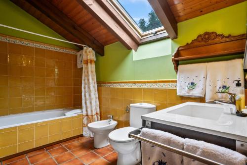 a bathroom with a toilet and a tub and a sink at Casa Jesusa in Gijón
