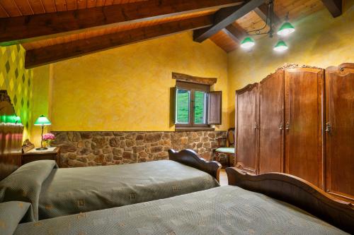 a bedroom with two beds and a wooden cabinet at Casa Jesusa in Gijón