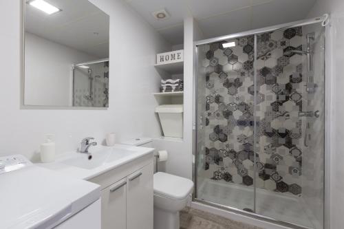 a white bathroom with a shower and a toilet at Lovely seaview apartment in Benalmadena Costa