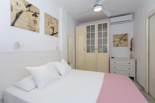 a white bedroom with a white bed and a cabinet at Lovely seaview apartment in Benalmadena Costa
