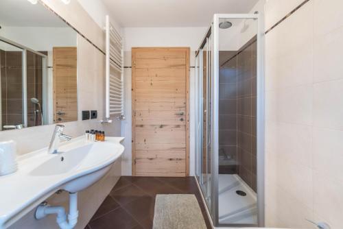 a bathroom with a sink and a shower and a tub at Appartamento Ciasa in Pozza di Fassa