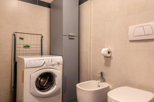 a bathroom with a washing machine and a toilet at Apartment Pordoi in Campitello di Fassa