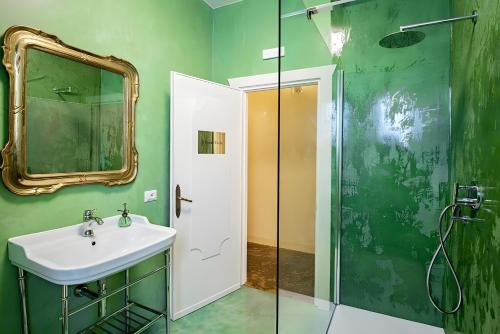 a green bathroom with a sink and a mirror at Elegant Central Large House F1F2 in Gravedona