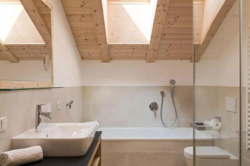 a bathroom with a tub and a sink and a shower at Natur Suite Edelweisshof App Georg in Chiusa