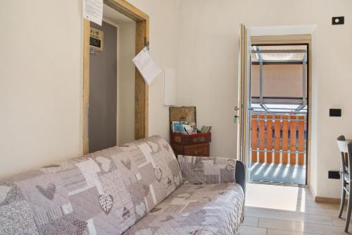 a living room with a couch and a sliding glass door at Ca Del Tita in Capo di Ponte