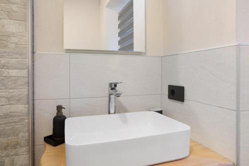 a bathroom with a white sink and a mirror at Ca Del Tita in Capo di Ponte