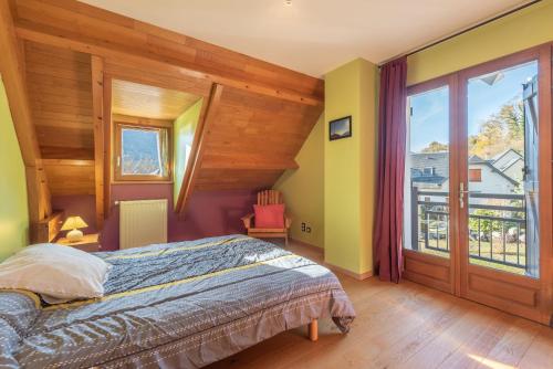 a bedroom with a bed and a large window at Maison Vacances Vue Montagnes in Arras-en-Lavedan