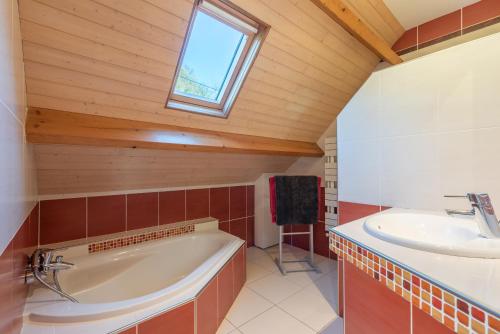 a bathroom with a large tub and a sink at Maison Vacances Vue Montagnes in Arras-en-Lavedan
