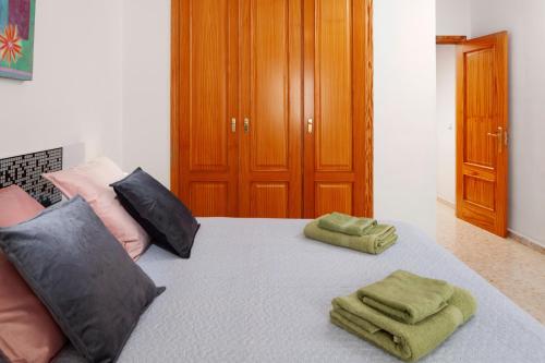a bedroom with a bed with two green towels on it at Apartamento Sugar Factory in Torre del Mar
