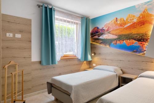 a bedroom with two beds and a painting on the wall at Night and day 4 in Predazzo