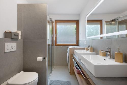 a bathroom with two sinks and a toilet at Night and day 4 in Predazzo