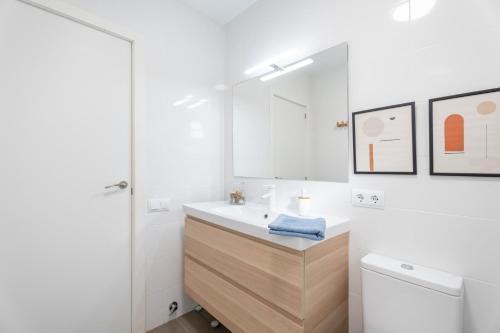 a white bathroom with a sink and a mirror at Chalet Saler in Valencia
