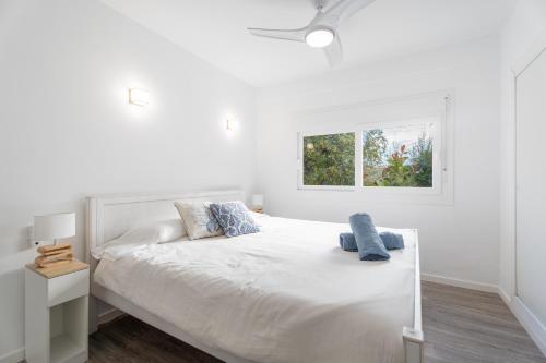 a white bedroom with a white bed with two pillows at Chalet Saler in Valencia