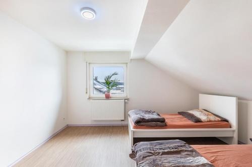 a bedroom with two beds and a window at Panda in Babenhausen