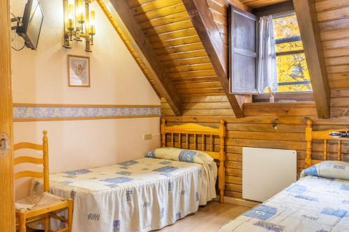 a bedroom with two beds in a log cabin at Apartamento La Mainera in Espot