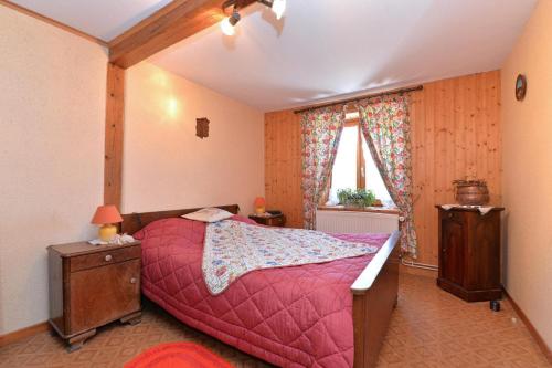 a bedroom with a bed with a red comforter at Les Hirondelles in Orbey