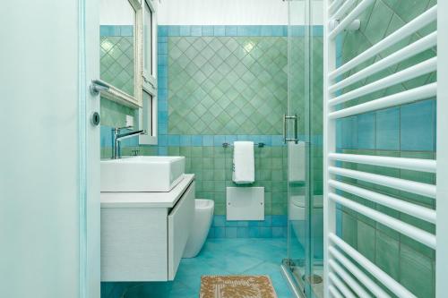 a blue bathroom with a sink and a toilet at Colombo Apartment - by And Service in Golfo Aranci