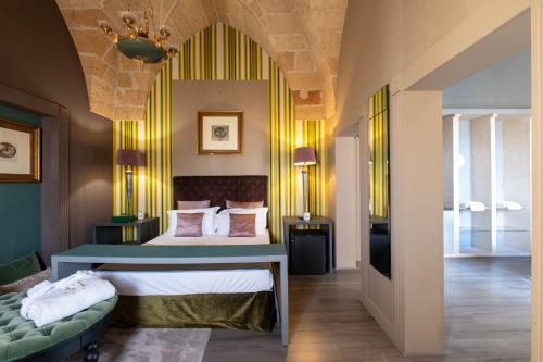 a bedroom with a bed and a couch in a room at Maison Boutique At Viviana in San Pietro in Lama
