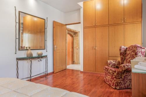 a room with a bed and a chair and a cabinet at Palailimnos in Palaiólimnos