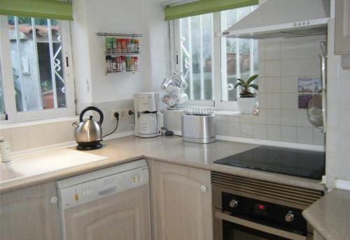 a white kitchen with a tea kettle on the counter at Casa Jazmin in Roses