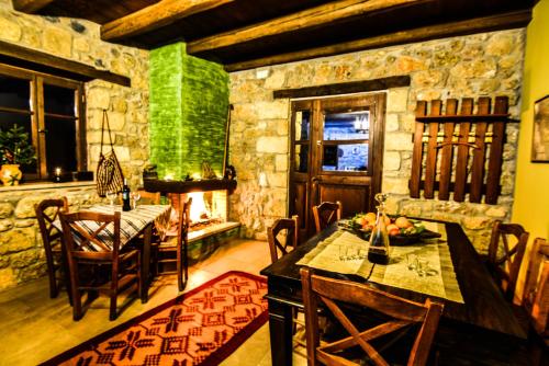 una sala da pranzo con tavolo e parete in pietra di Korfes Guesthouse a Synikia Mesi Trikalon