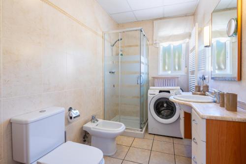 a bathroom with a toilet sink and a washing machine at Villa Individual Peñíscola in Peniscola