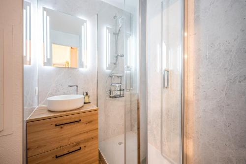 a bathroom with a sink and a shower with a mirror at Appartement Les Menuires in Les Menuires