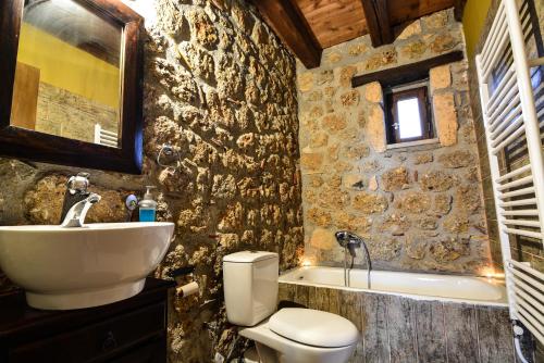 e bagno con lavandino, servizi igienici e vasca. di Korfes Guesthouse a Synikia Mesi Trikalon