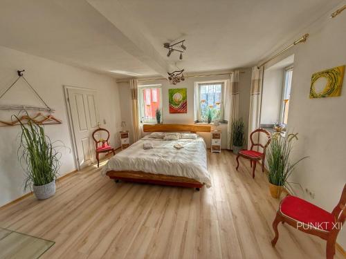 a large bedroom with a bed and two chairs at Wohnung 8 in Burghaslach