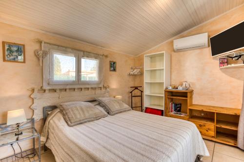 a bedroom with a bed and a window and a tv at Chez Gaston - Chambre in Saint-Drézéry
