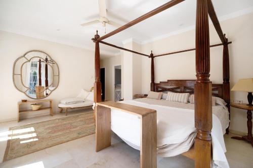 a bedroom with a four poster bed and a mirror at Olmo tree in Vista Hermosa
