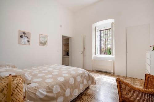 a white bedroom with a bed and a window at Maison Valentina in Monopoli