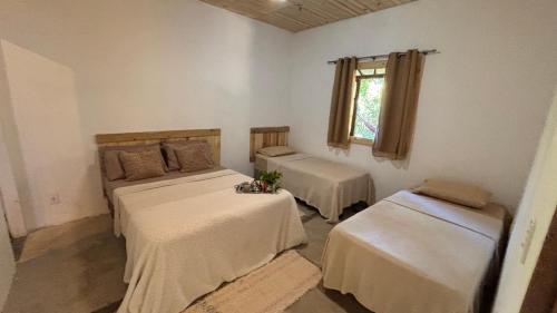 a room with two beds and a window at Casa natureza Paraty II in Paraty