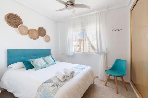 a bedroom with a bed and a blue chair at Mistral Apartment La Manga in San Javier