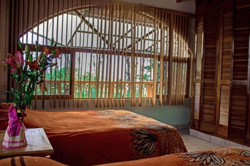 a bedroom with two beds and a large window at Cabañas Monte Escondido in Mazamitla