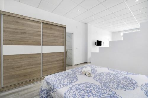 a bedroom with a bed and a large wall at Apartamento Venus 2 in Conil de la Frontera