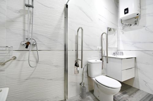 a white bathroom with a shower and a toilet at Apartamento Venus 2 in Conil de la Frontera
